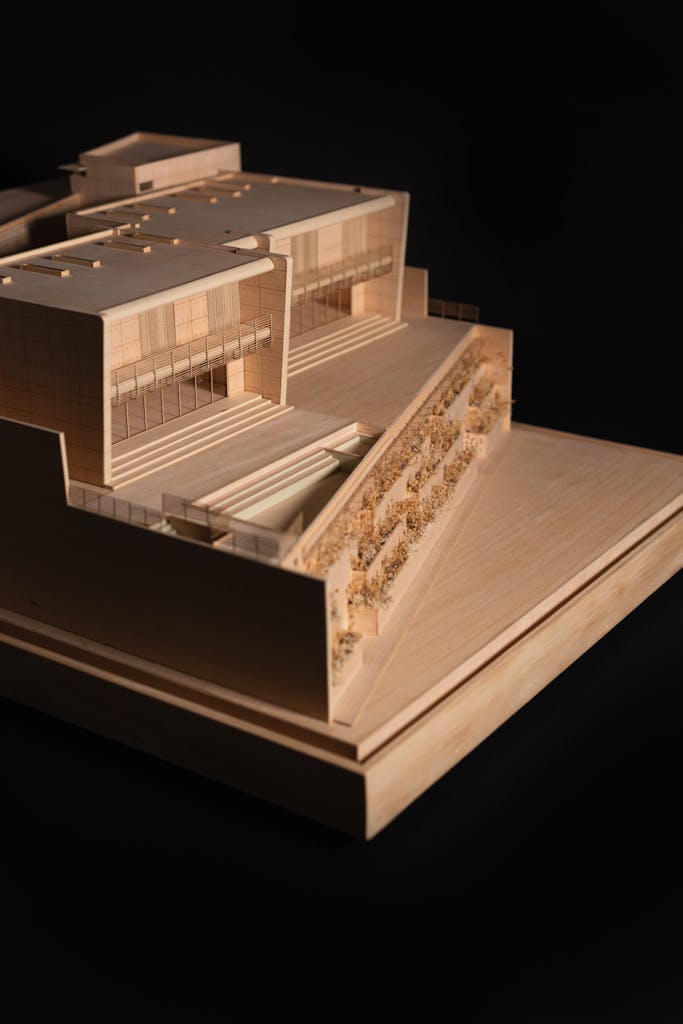 Detailed wooden architectural model displayed against a black background.