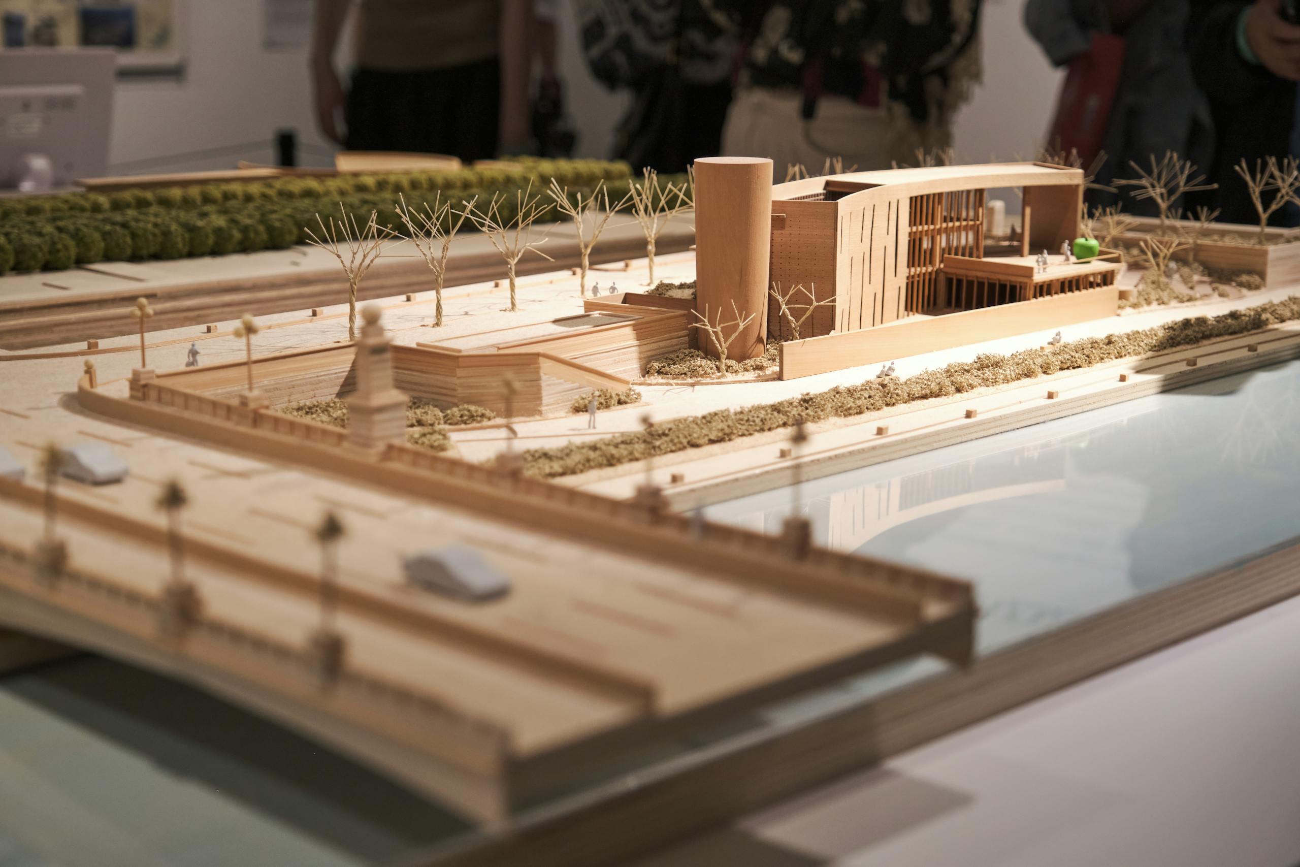 Detailed wooden architectural scale model displayed in an exhibition environment.